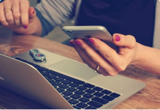 Woman using phone and laptop