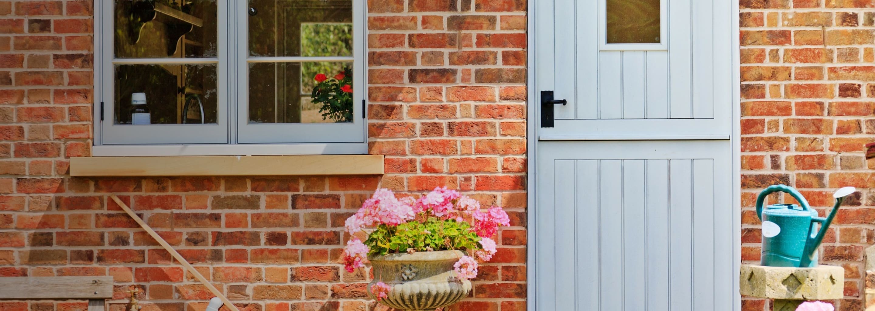 a door to a house with a plant pot outside it