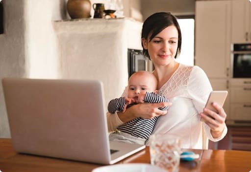 Woman holding her baby in her arms while holding a mobile phone