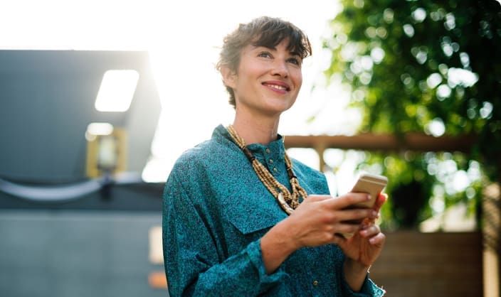 women smiling while using mobile phone