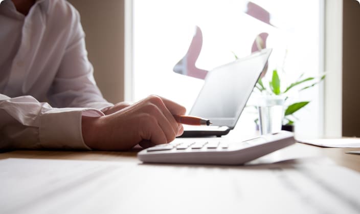 Man at desk with laptop and calculator