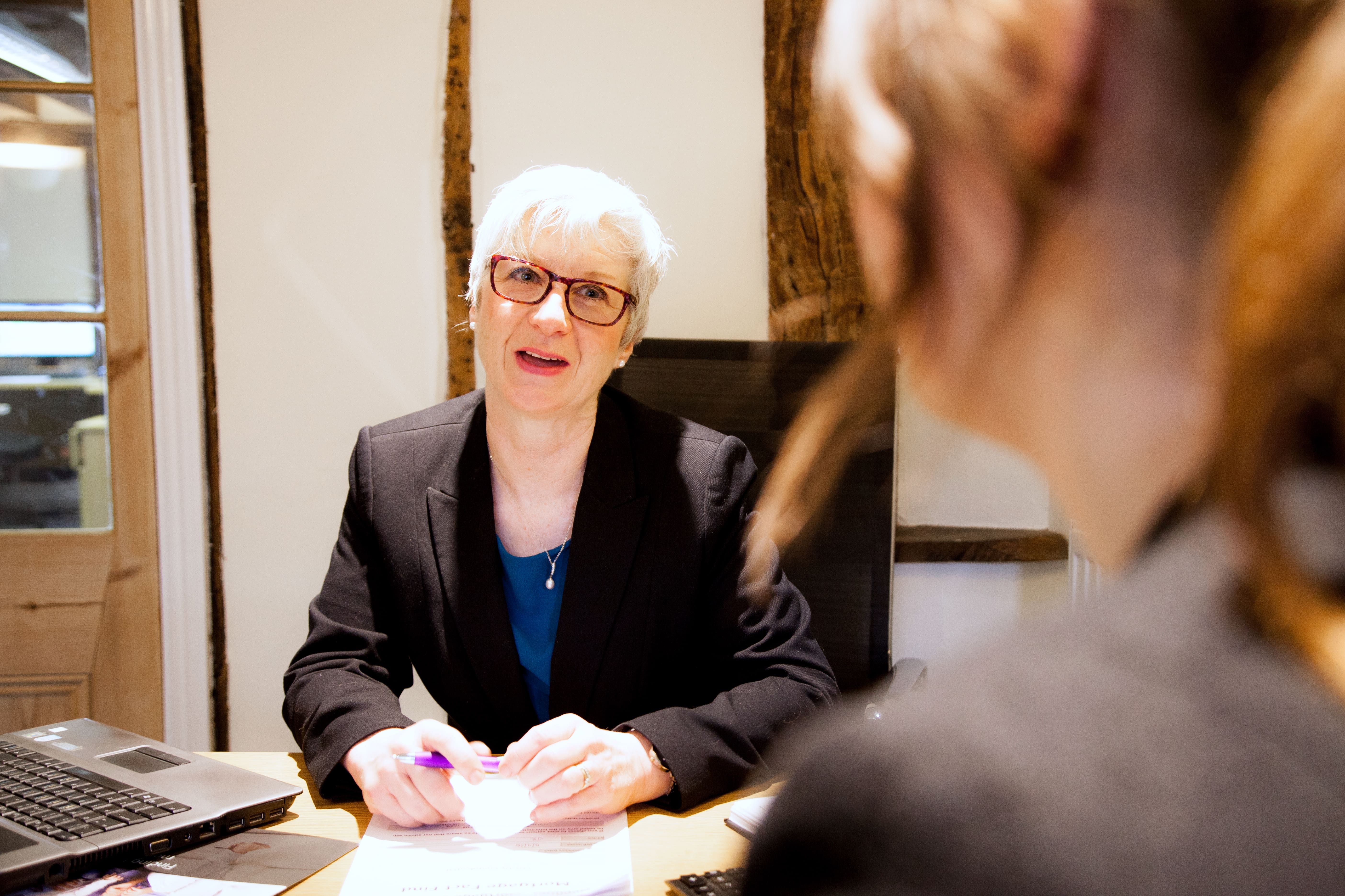 woman with white hair and red glasses