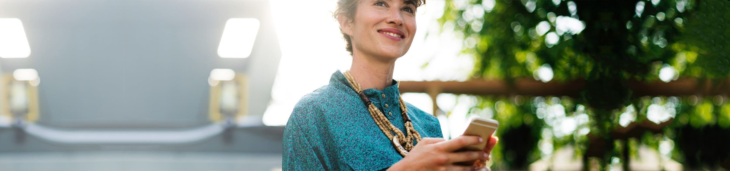 women smiling while using her mobile phone