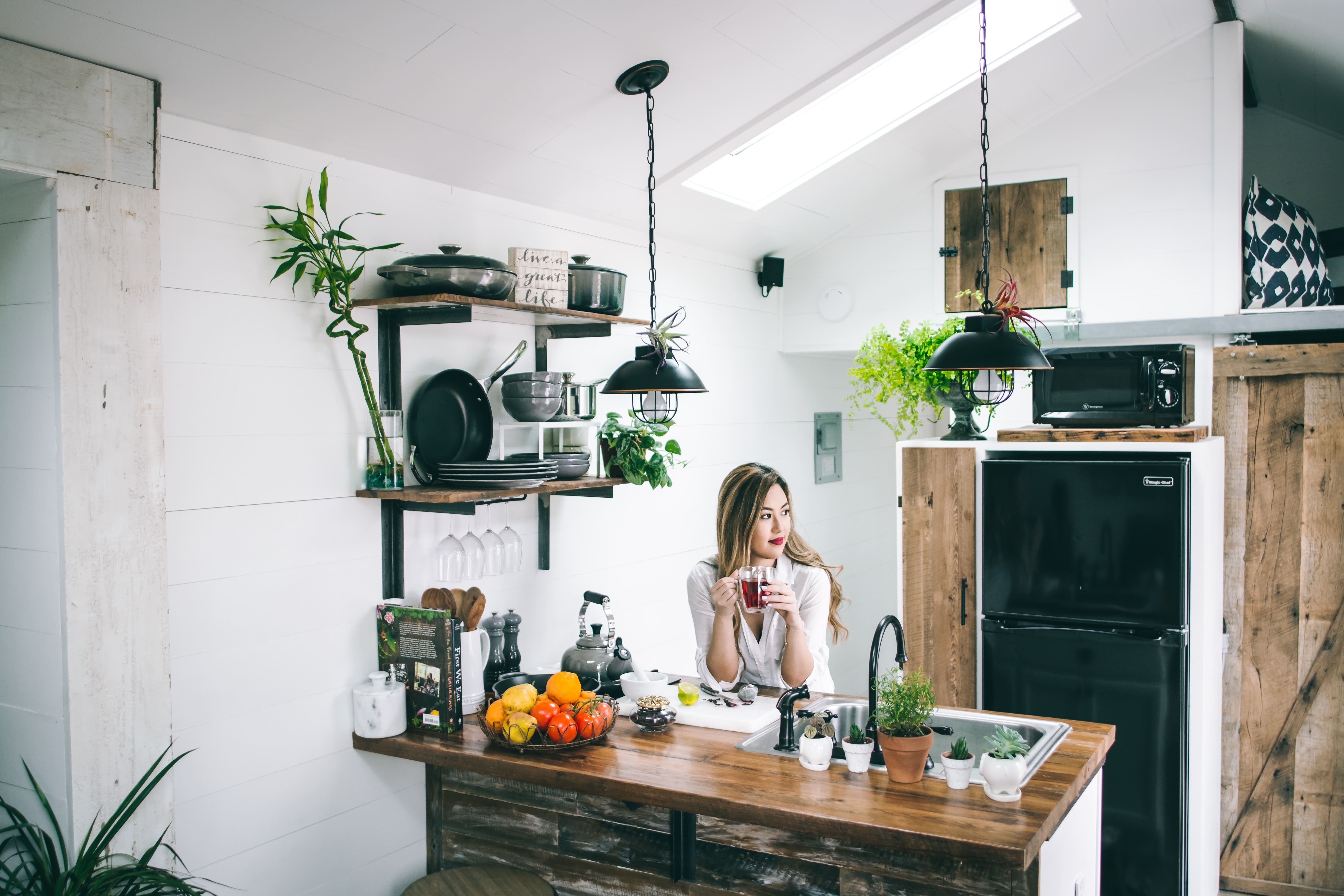 a woman in a kitchen drinking tea