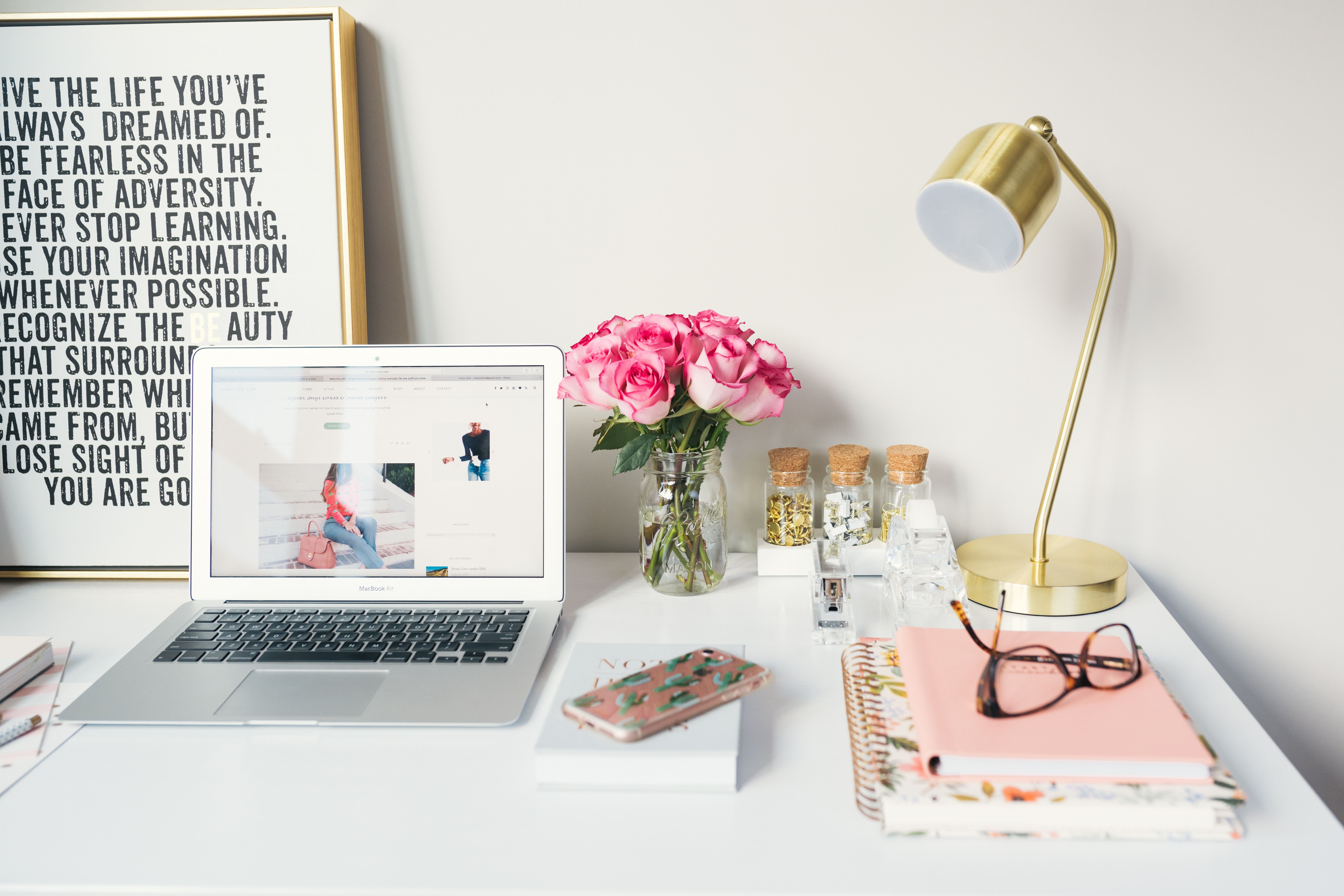 a desk with a laptop and lamp