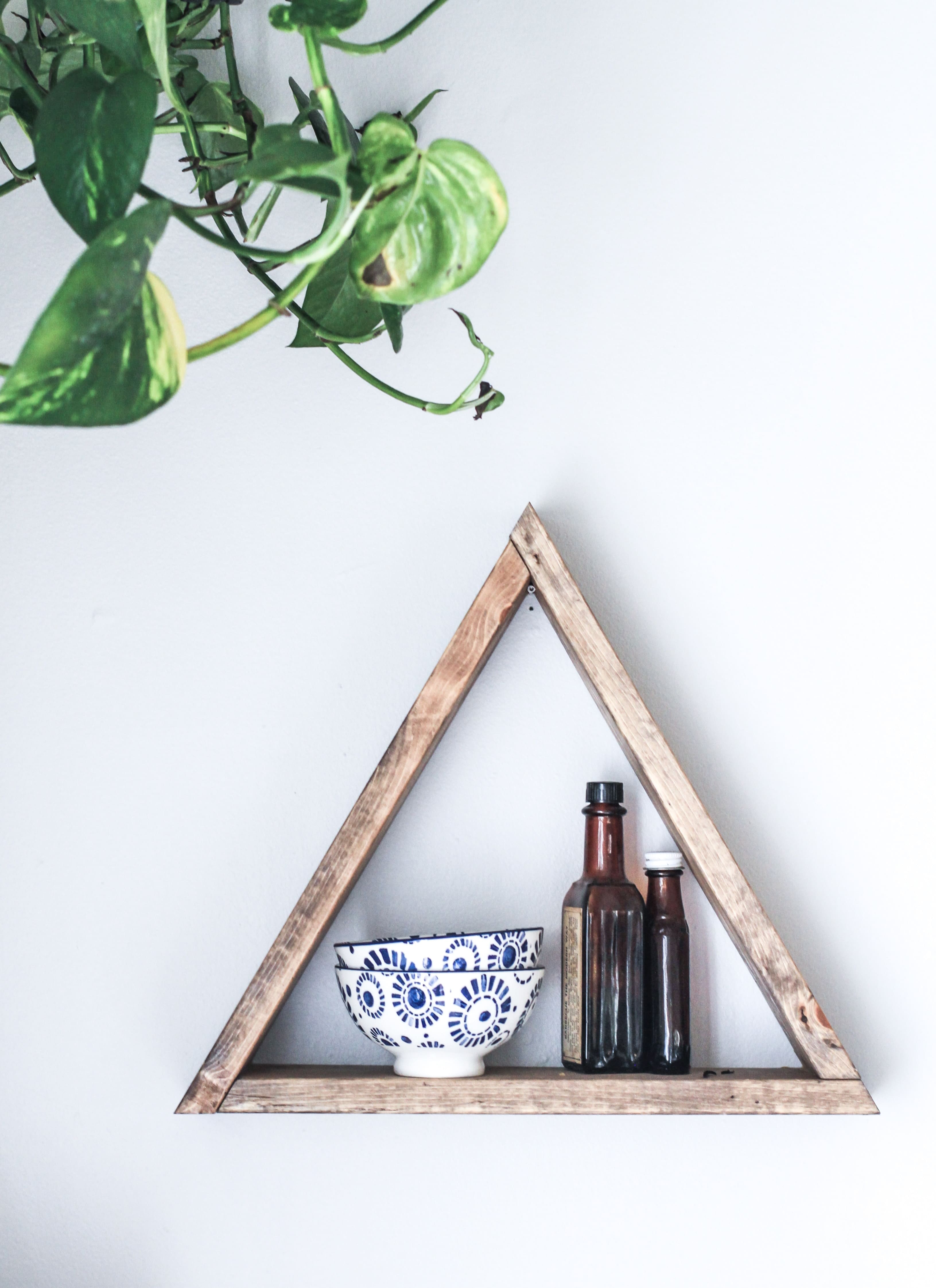 a triangle shaped shelf with bowls on it