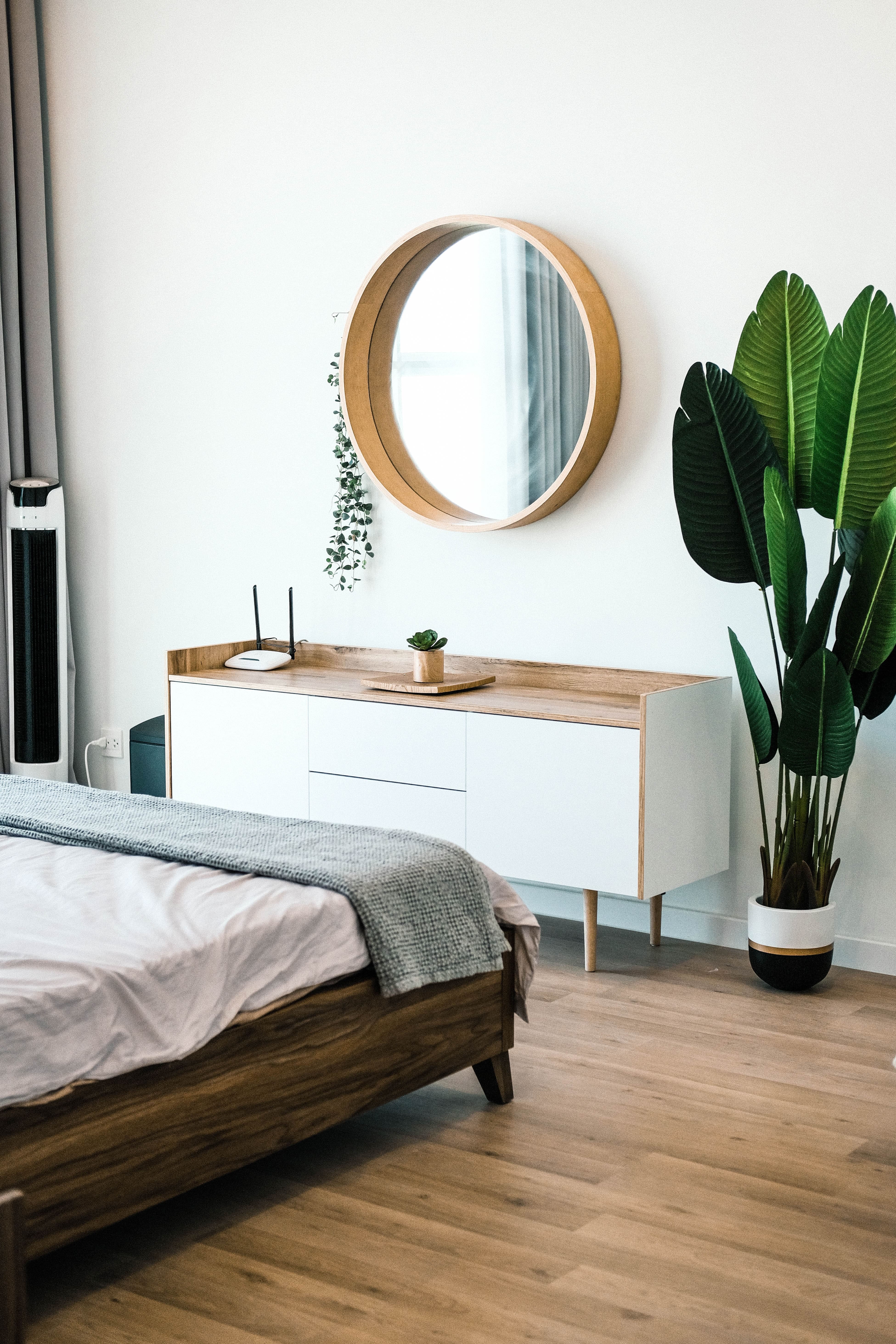 a bed with a circular mirror opposite