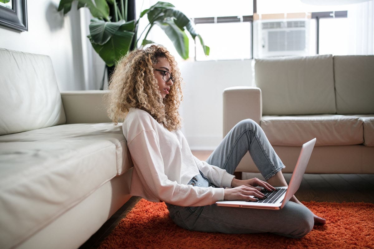 woman sat on the floor on her laptop