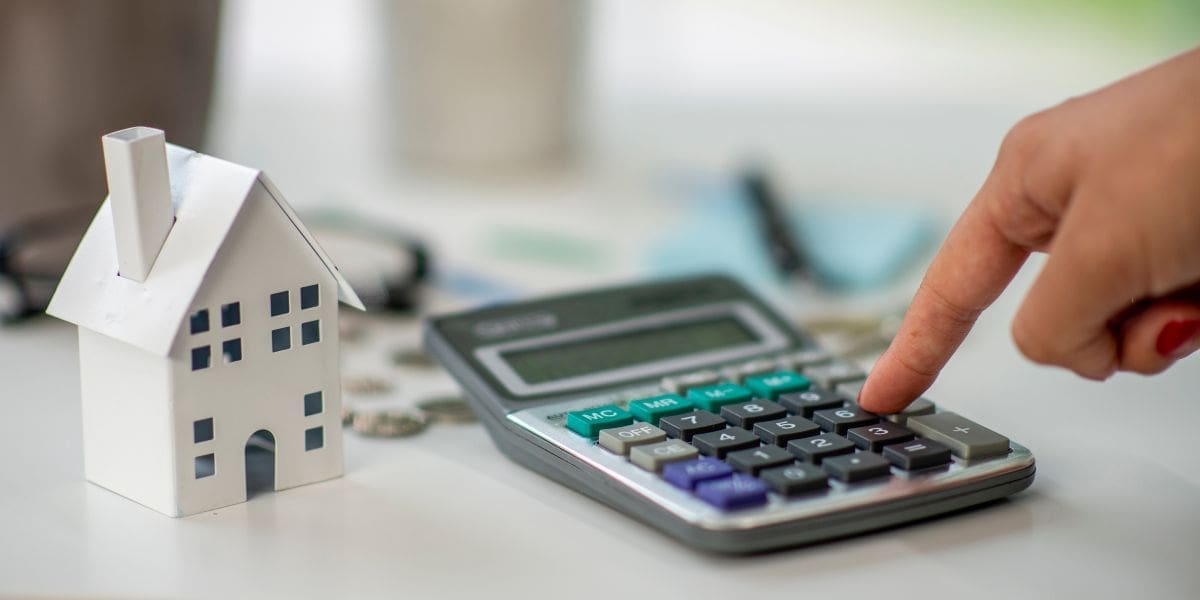 a calculator next to a model house