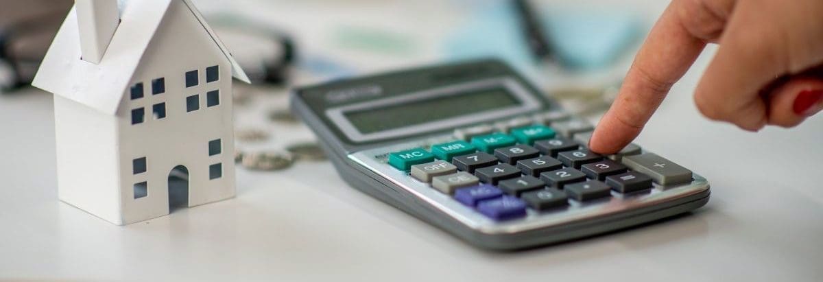 a calculator next to a model house