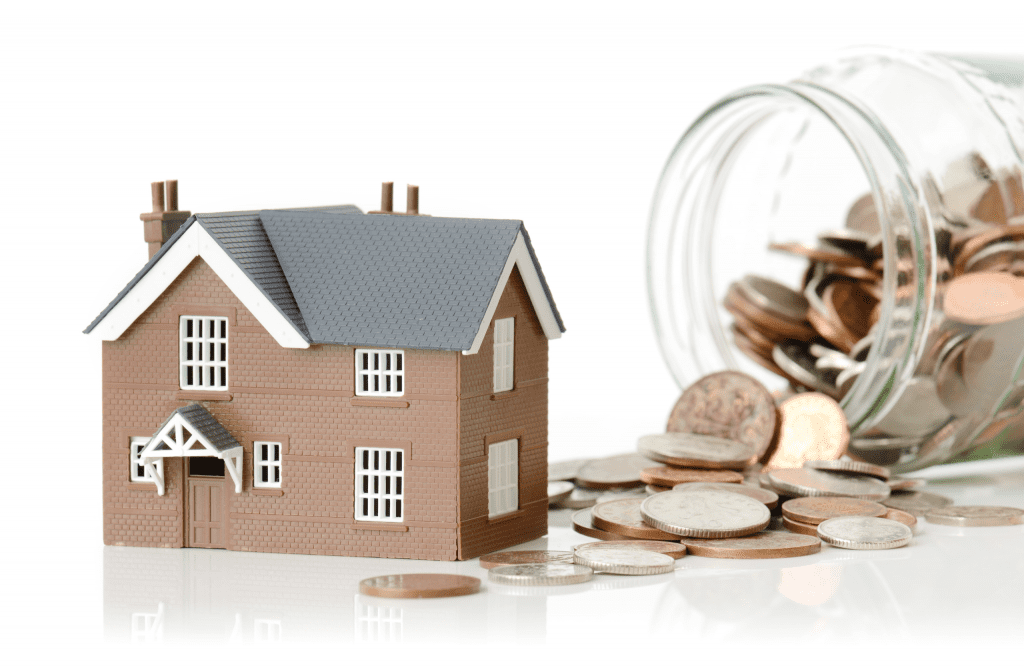 small model house next to a spilt jar of pennies